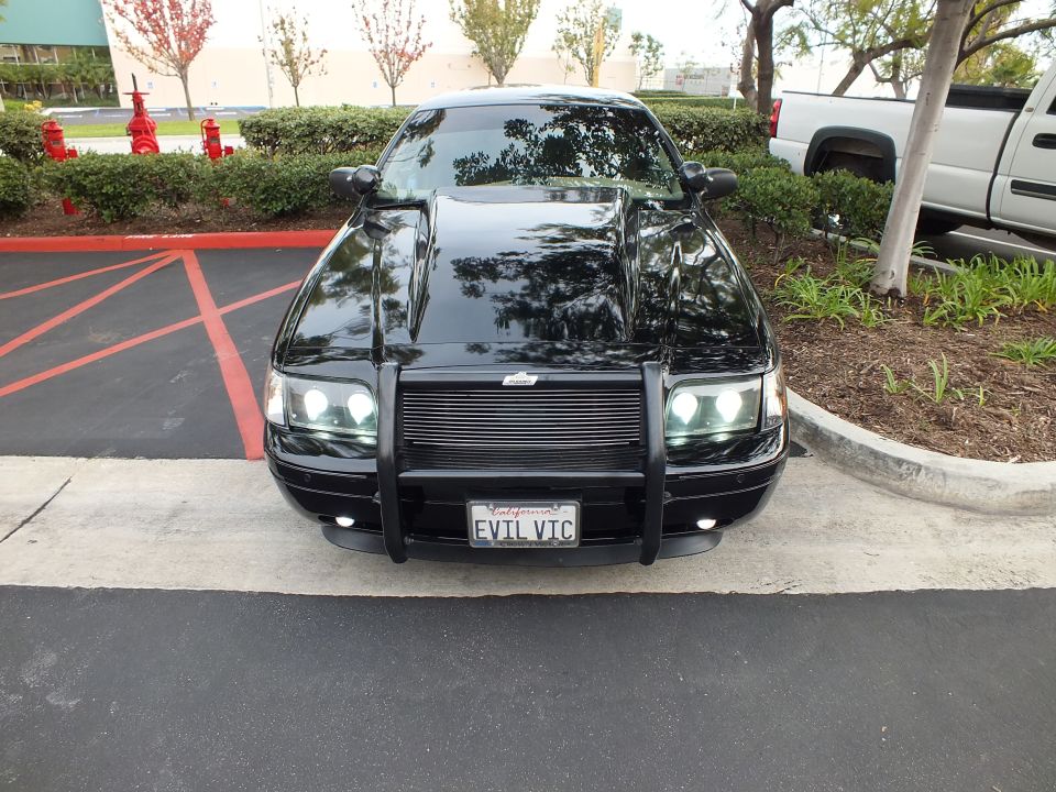 Head-on front view of black Crown Victoria with brush guard and EVIL VIC plate