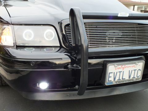 2003 Ford Crown Victoria - Front quarter of a modified Crown Victoria showing the EVIL VIC plate, billet grille and black push bar.