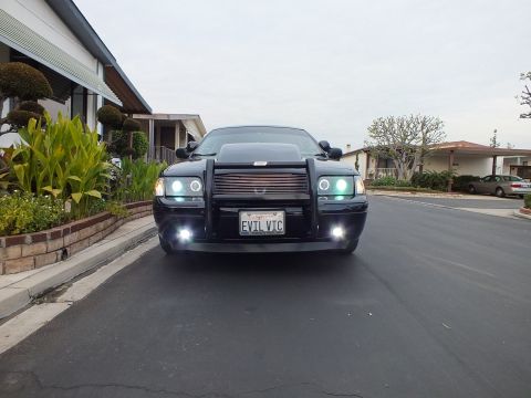 2003 Ford Crown Victoria - Front view of a black Crown Victoria in a residential driveway with billet grille and EVIL VIC plate.