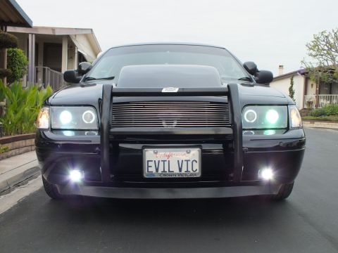 2003 Ford Crown Victoria - Front view of a Crown Victoria with brightly lit halo headlights, billet grille and EVIL VIC California plate.