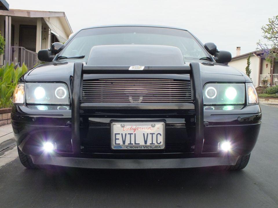 Black Crown Victoria head-on with lit halo headlights, fog lamps and EVIL VIC plate