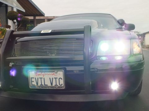 2003 Ford Crown Victoria - Dusk front view of a Crown Victoria with glowing headlights, fog lamps, push bar and EVIL VIC plate.