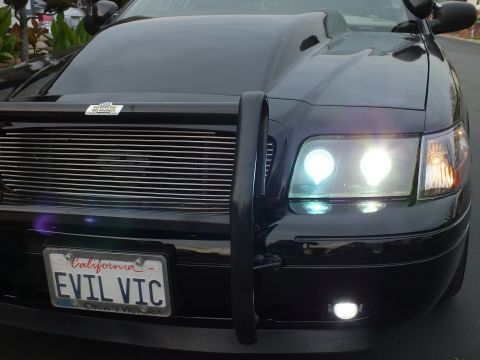 2003 Ford Crown Victoria - Front-corner view of a Crown Victoria with bright dual headlights, billet grille and push bar.