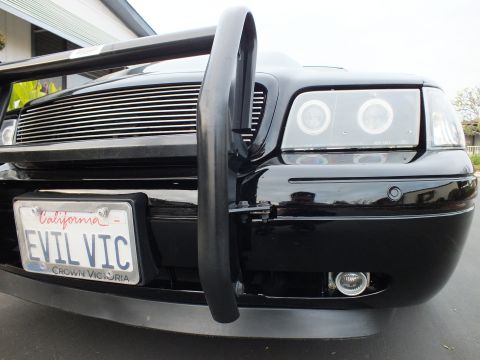2003 Ford Crown Victoria - Angled front shot highlighting the grille guard, fog lamp and EVIL VIC license plate.
