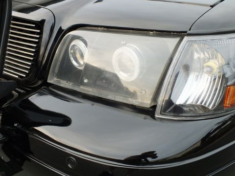 2003 Ford Crown Victoria - Angled detail of dual halo rings and amber marker within a clear headlight housing.