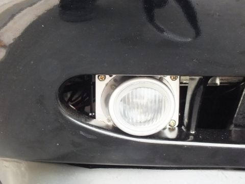 2003 Ford Crown Victoria - Close detail of a circular fog light mounted in the lower front bumper.