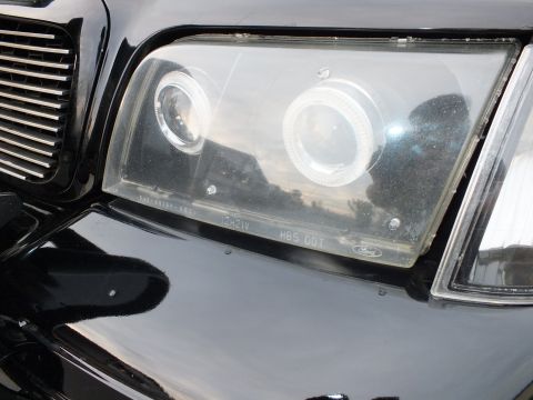 2003 Ford Crown Victoria - Close detail of dual halo projector beams within a clear headlight housing.