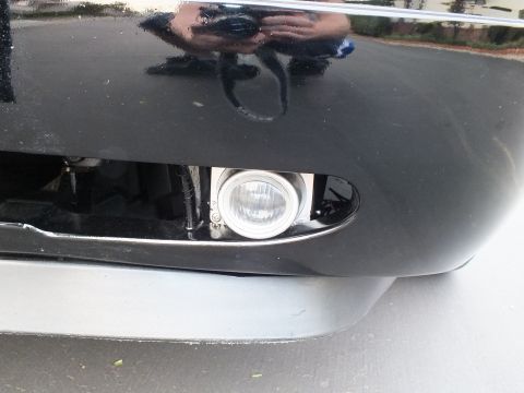 2003 Ford Crown Victoria - Low fog lamp set into a black bumper, hood reflecting the photographer above.