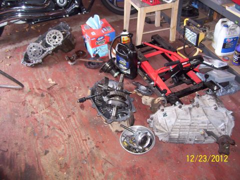 1990 Ford Bronco - Various vehicle transmission and transfer case components are laid out on a garage floor, dated 12/23/2012.
