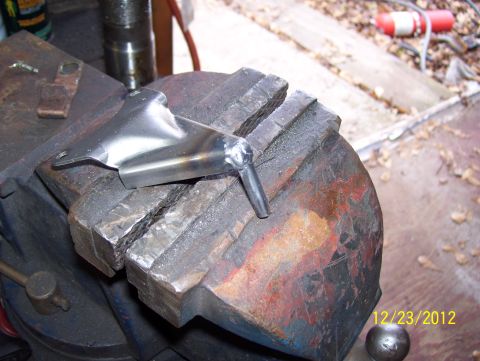 1990 Ford Bronco - Metal bracket held in a vise, likely for repair or modification.