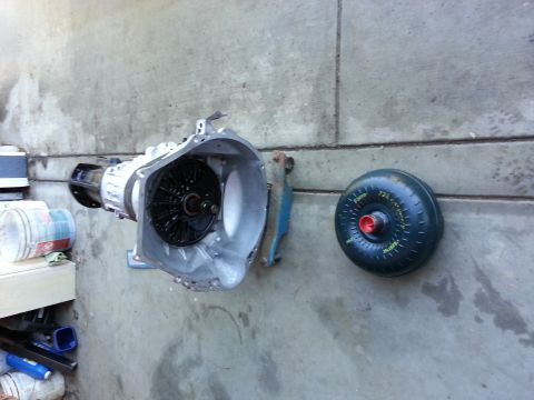 1978 Ford Bronco - An automatic transmission and its torque converter are displayed on a concrete surface, possibly for repair or replacement.