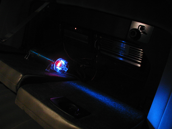 Car interior with a blue and red light stick and an amplifier in the dark