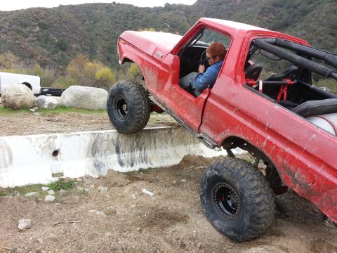 1978 Ford Bronco - A modified red truck navigates an obstacle course, its off-road capabilities.