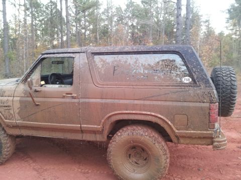 1986 Ford Bronco - This muddy SUV's body style suggests it is from the 1980s, not 1986.