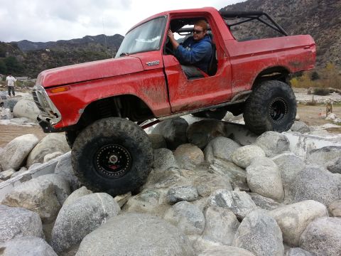 1978 Ford Bronco - A red Ford Bronco navigates a rocky obstacle course.