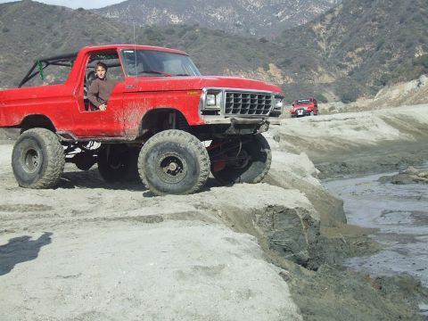 1978 Ford Bronco - Modified 1978 Ford Bronco tackling rough terrain with a second vehicle in the distance.