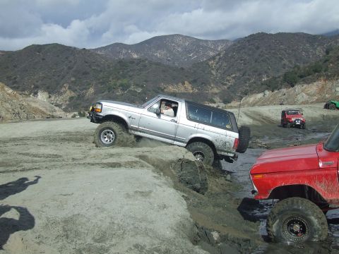 1978 Ford Bronco - Off-roading adventure with multiple vehicles in a hilly, dusty environment.