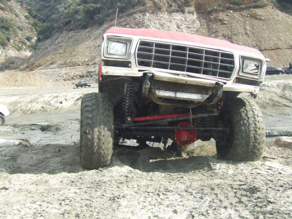 1978 Ford Bronco with large off-road tires on sandy terrain