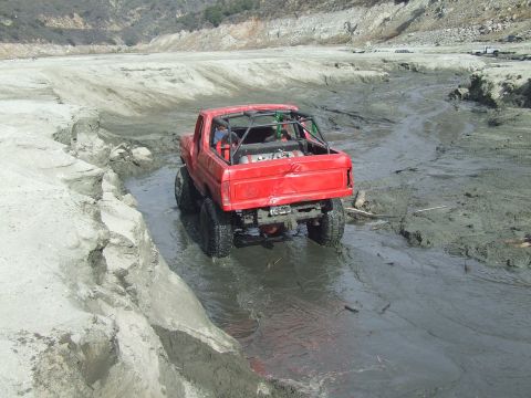 1978 Ford Bronco - This modified truck navigates a muddy terrain, kicking up water as it goes.