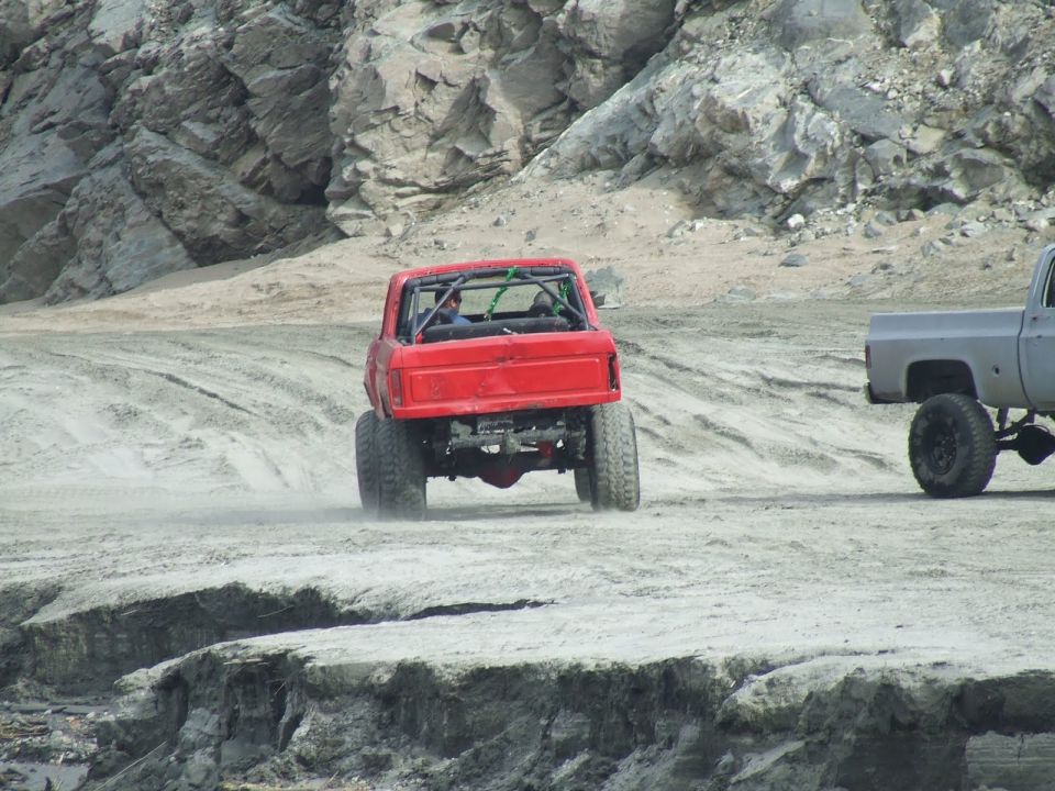 Red off-road truck with roll cage, rear view