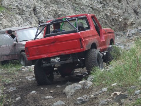 1978 Ford Bronco - A red 1978 Ford Bronco navigates a challenging rocky terrain alongside another vehicle.