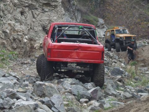1978 Ford Bronco - A red 1978 Ford Bronco navigates a rocky trail, with another off-road vehicle visible in the background.