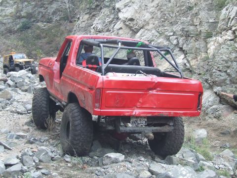 1978 Ford Bronco - Modified 1978 Ford Bronco navigates a rocky off-road path with another vehicle in the background.