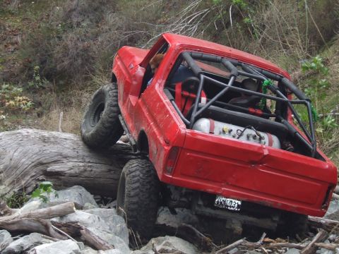 1978 Ford Bronco - This modified SUV is navigating a difficult off-road obstacle course with large tires and a reinforced frame.