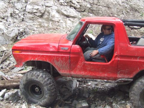 1978 Ford Bronco - A red 1978 Ford Bronco navigates a rocky trail, showing its off-road capabilities.