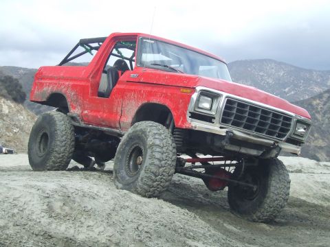 1978 Ford Bronco - A red 1978 Ford Bronco is shown modified for off-road use on a dirt incline.