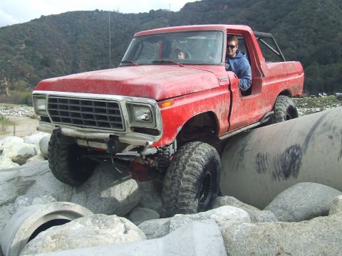 1978 Ford Bronco - A red 1978 Ford Bronco navigates a rocky obstacle course.