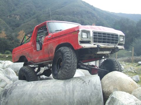 1978 Ford Bronco - This modified SUV is navigating a rocky terrain, its off-road capabilities.