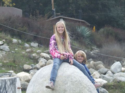 1978 Ford Bronco - Two children smile while sitting on a large rock in an outdoor, rocky environment.