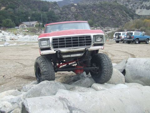 1978 Ford Bronco - This lifted 1978 Ford Bronco navigates a rocky trail, with other SUVs visible in the background.