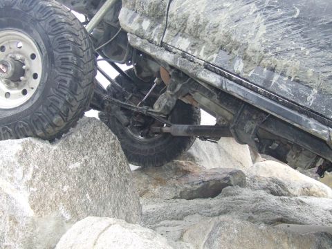 1978 Ford Bronco - Vehicle navigating a rocky terrain, showing suspension and tire details.