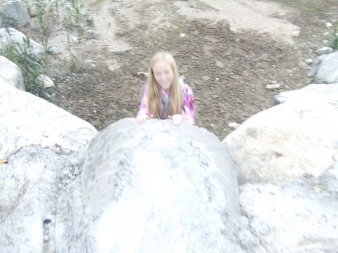 1978 Ford Bronco - A young girl is seen peeking over a large rock formation in an outdoor setting.