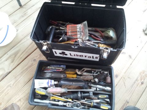 1986 Ford Bronco - An open toolbox reveals a collection of tools, including screwdrivers, pliers, and wrenches, resting on a wooden surface.