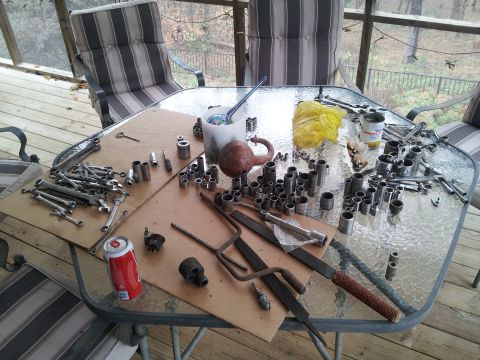 1986 Ford Bronco - Tools and a soda can are laid out on a table, likely for a repair or maintenance task.