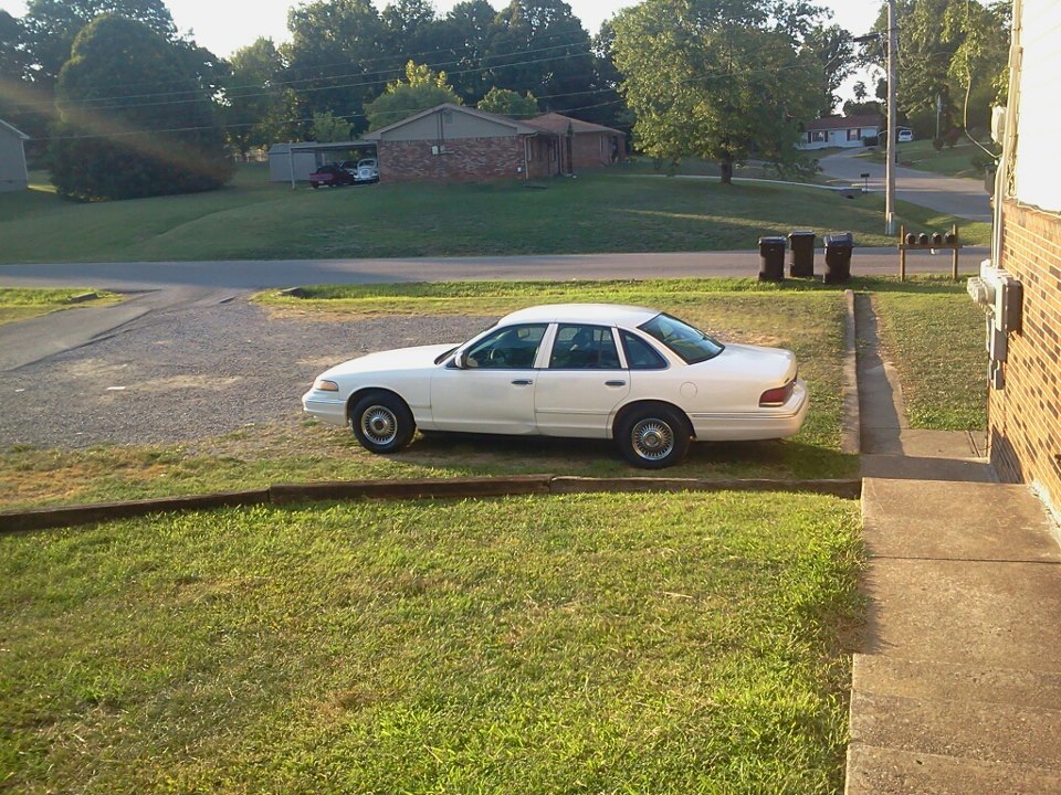 White 1997 Ford Crown Victoria parked on grass, side view