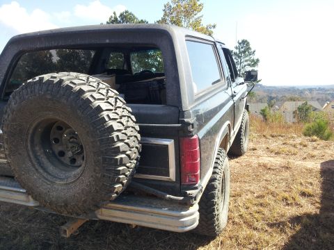 1986 Ford Bronco - This 1986 Ford Bronco is seen from the rear, a spare tire mounted on the tailgate and a scenic overlook in the background.