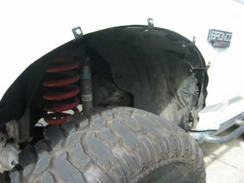 1992 Ford Bronco - close up of the crunched drivers side fender.