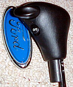 2003 Ford Expedition - Close-up of a Ford gear shifter with the iconic blue oval Ford emblem visible.