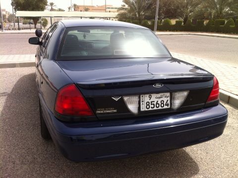 2007 Ford Crown Victoria - The rear of a dark blue 2007 Ford Crown Victoria Police Interceptor is visible, parked outdoors.