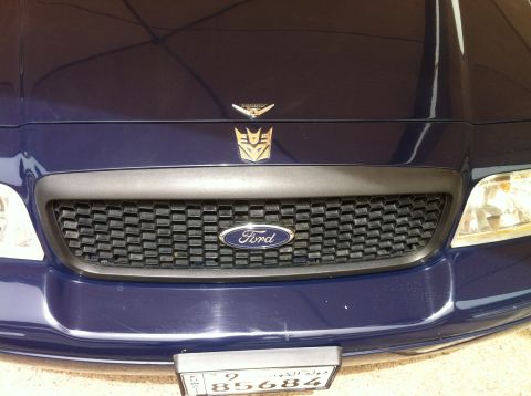 2007 Ford Crown Victoria - The front of a dark blue Ford Crown Victoria features a prominent grille and hood ornaments.