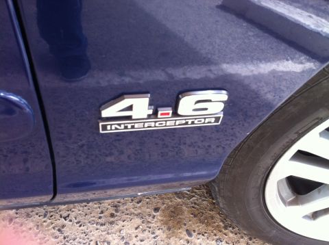 2007 Ford Crown Victoria - Close-up of the 4.6 INTERCEPTOR badge on a blue vehicle.