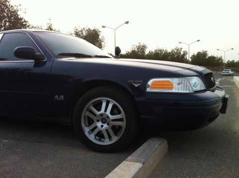 2007 Ford Crown Victoria - Front quarter view of a dark blue 2007 Ford Crown Victoria, showing the headlight and grille.