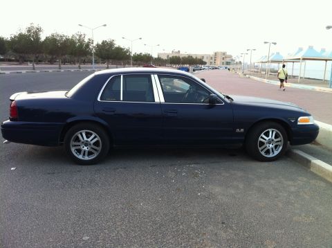 2007 Ford Crown Victoria - Side profile of a dark blue 2007 Ford Crown Victoria sedan parked on an asphalt lot.