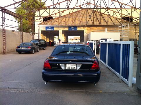 2007 Ford Crown Victoria - A dark blue 2007 Ford Crown Victoria is seen from the rear at a checkpoint or inspection station.