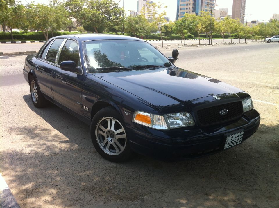 Dark blue 2007 Ford Crown Victoria parked on a street, front 3/4 view, with chrome trim and alloy wheels
