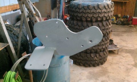 1995 Ford Bronco - A metal bracket, possibly for a vehicle suspension, is shown in a workshop setting.